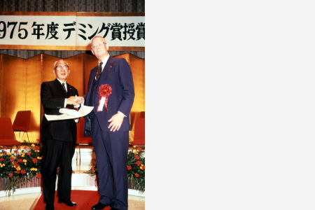 受賞式でデミング博士と握手を交わす舘林社長（経団連会館1975年11月17日）