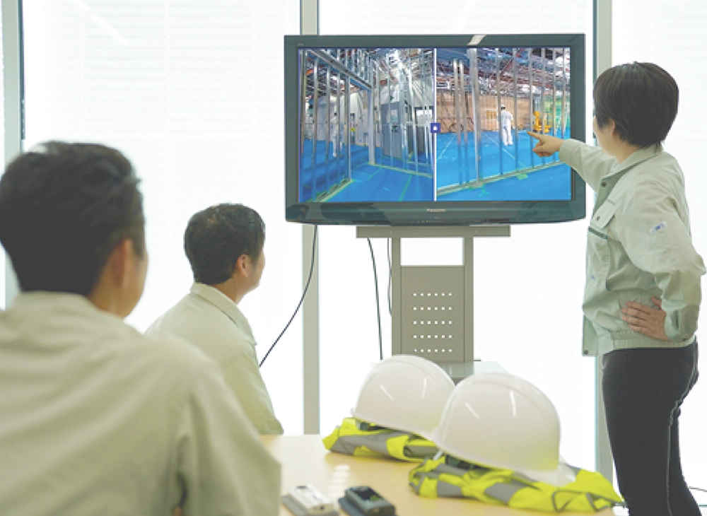 リコーの360度カメラで撮影した現場の様子を見ながら打ち合わせをしている場面。